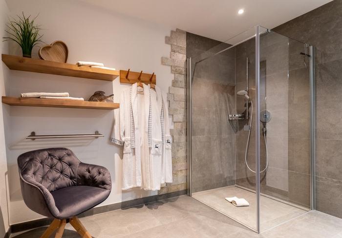 Badezimmer mit ebenerdiger Dusche und Bademänteln