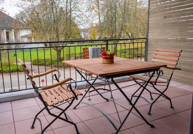 Balkon mit Tisch und Stühlen ins Grüne